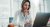 Confident businesswoman working on laptop at her workplace at modern office.Blurred background.