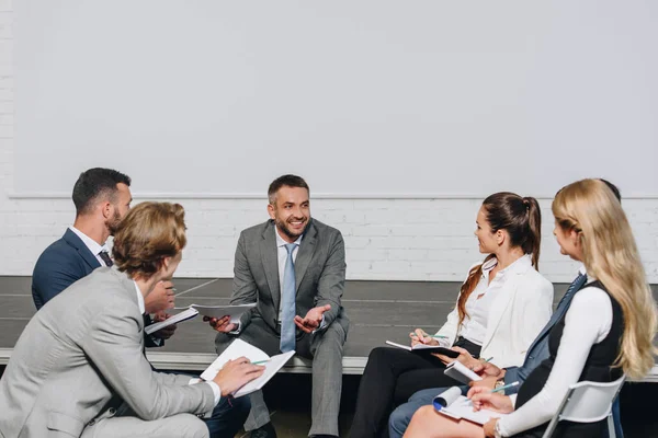 depositphotos_209197866-stock-photo-handsome-business-coach-looking-businesspeople